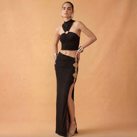 Woman wearing a black dress with cut-out design on a beige background